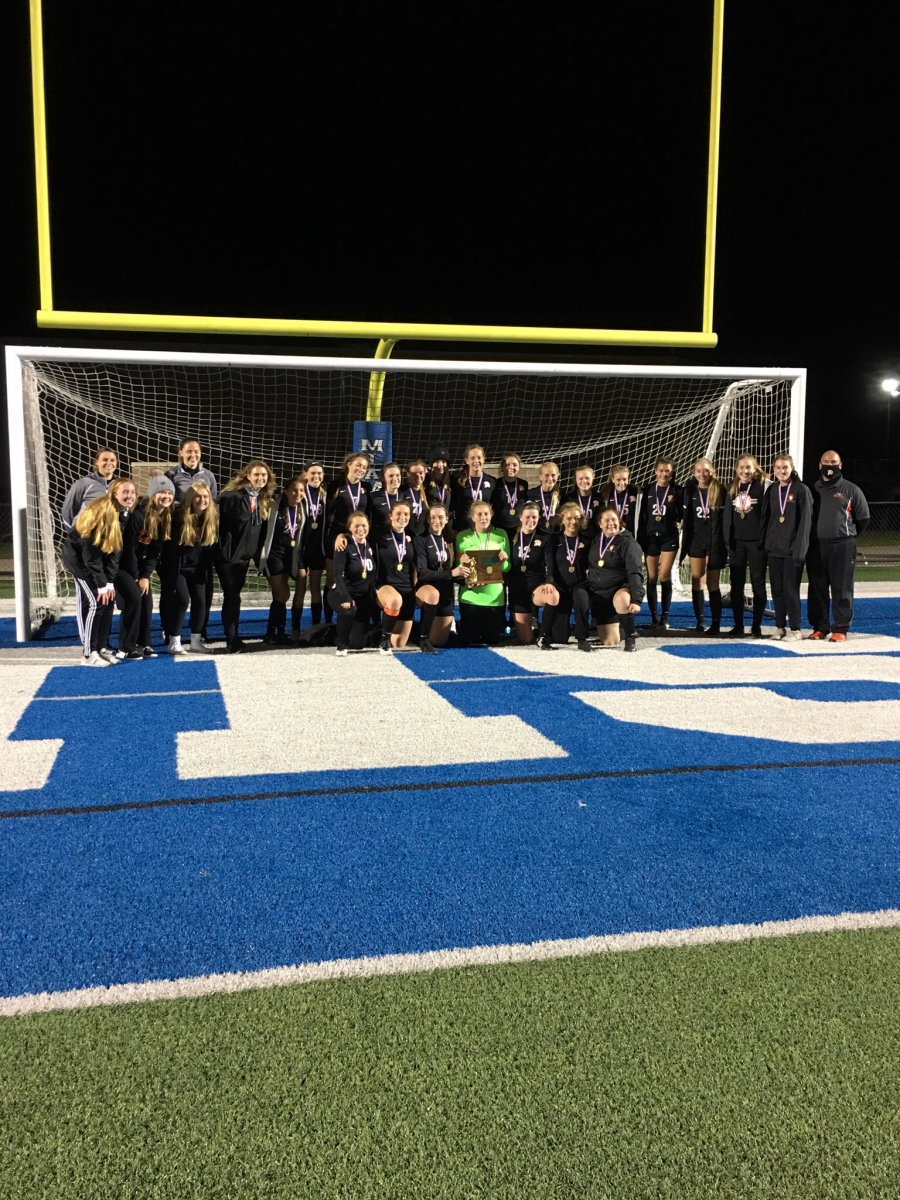 Girls soccer team in front of a net