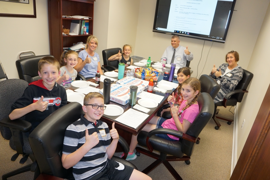 people around a table giving thumbs up