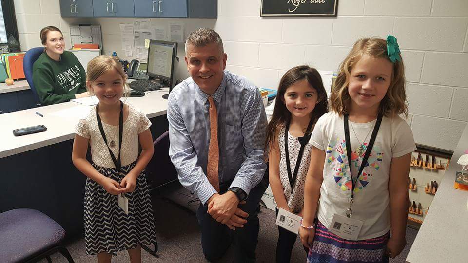 image of a man wearing a tie and three small children