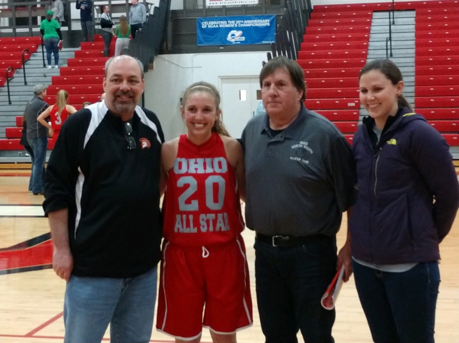 coaches and a player all smiles as they pose for a photo