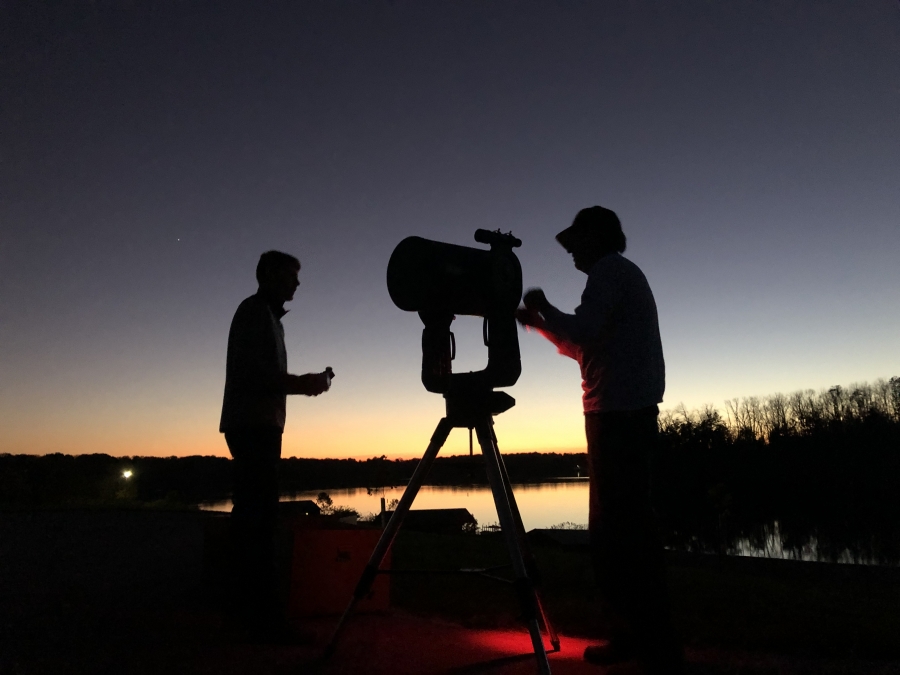 silhouette of two people at a camera