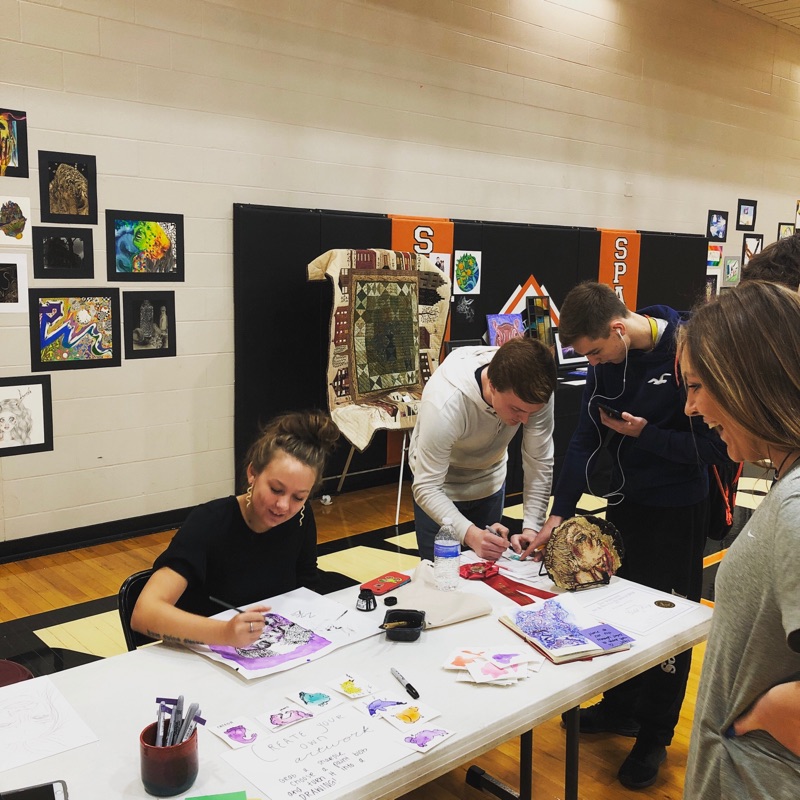 students working on art pieces at a table