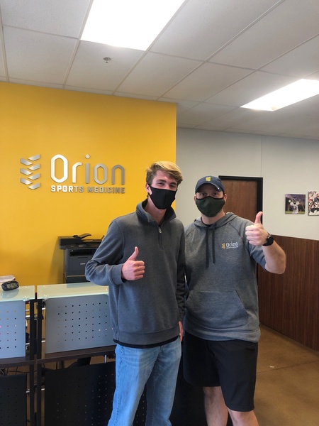 two men smiling in a doctor office