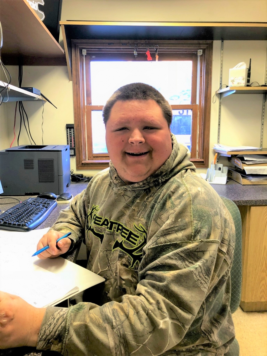 man in a camo sweatshirt at a desk