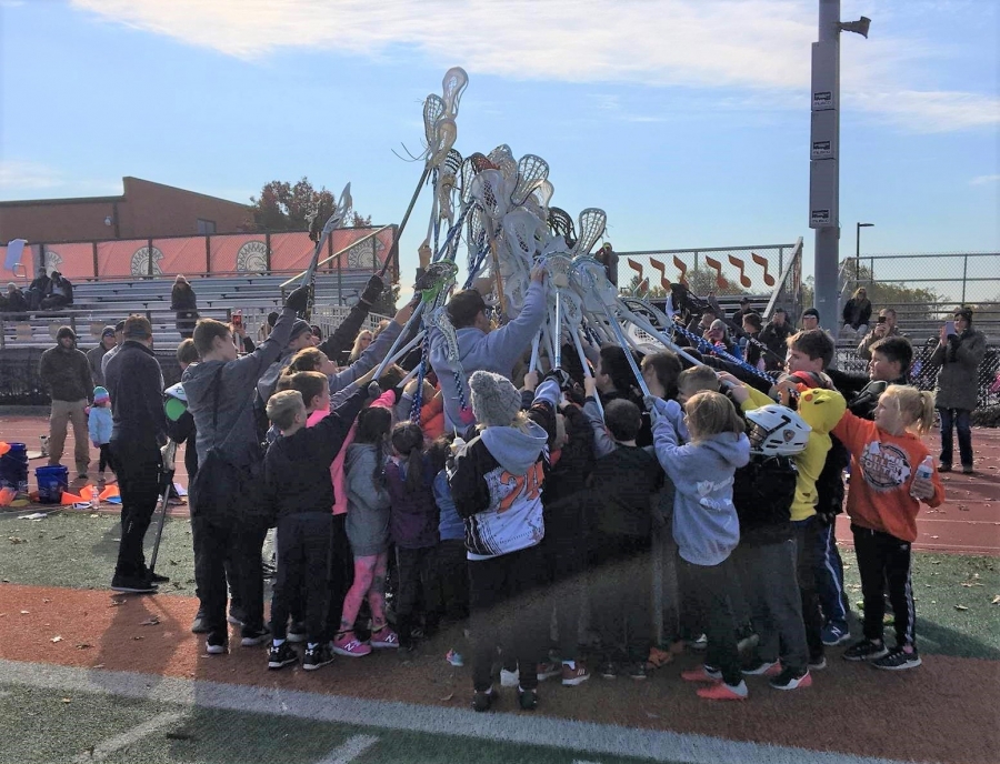 group with lacrosse sticks up in the air