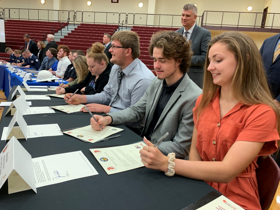 people seating a table signing paper