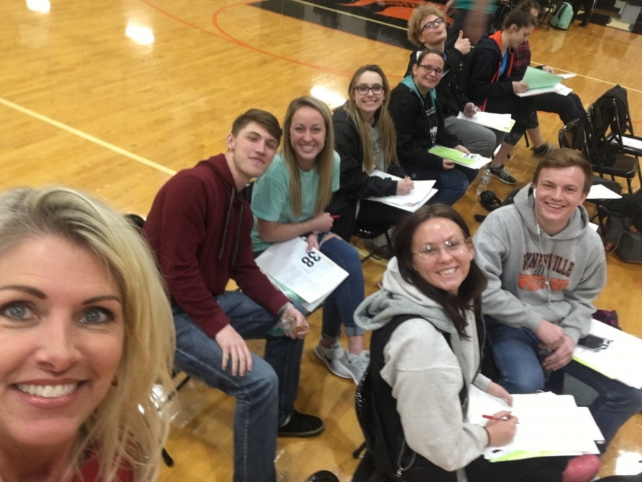 students sitting in chairs with clipboards on their laps