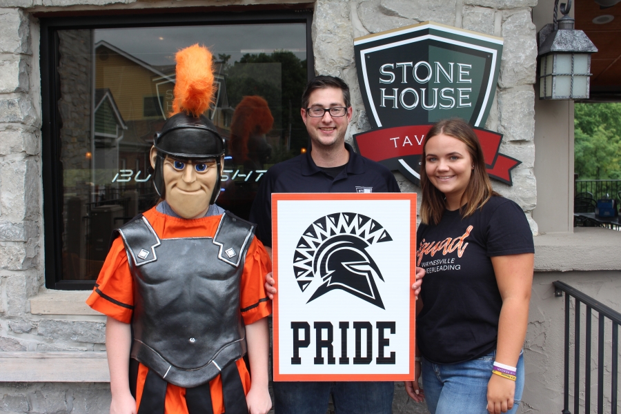 spartan mascot and three people holding a sign