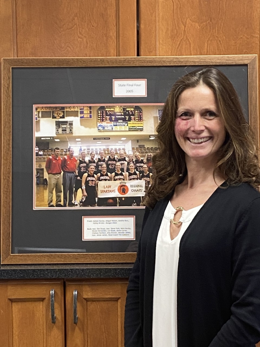 woman smiling in front of a team photo