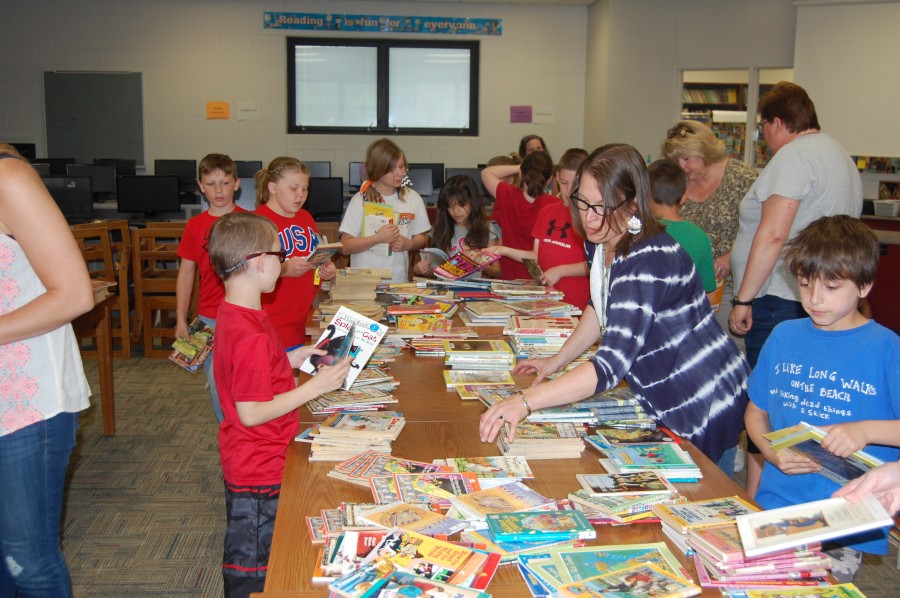 people looking at a table full of magazines