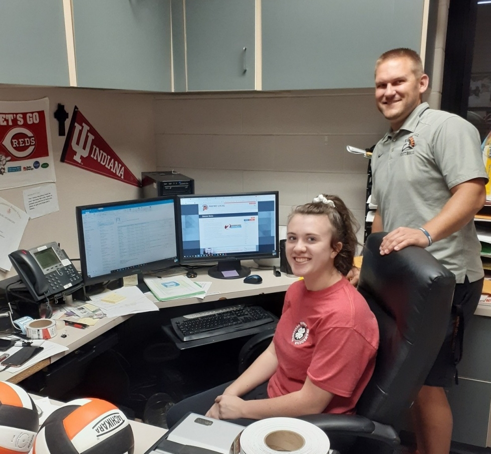 girl and a man behind a desk